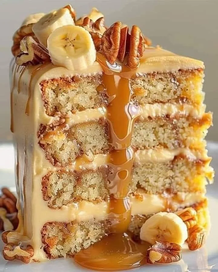 Moist banana pecan cake with a drizzle of icing and pecans on top
