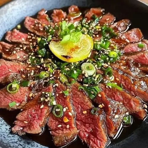 Delicious Beef Tataki served with dipping sauce and garnishes.