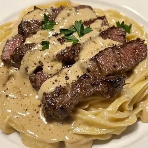 Cajun creamy steak alfredo dish with steak and pasta in a rich sauce.