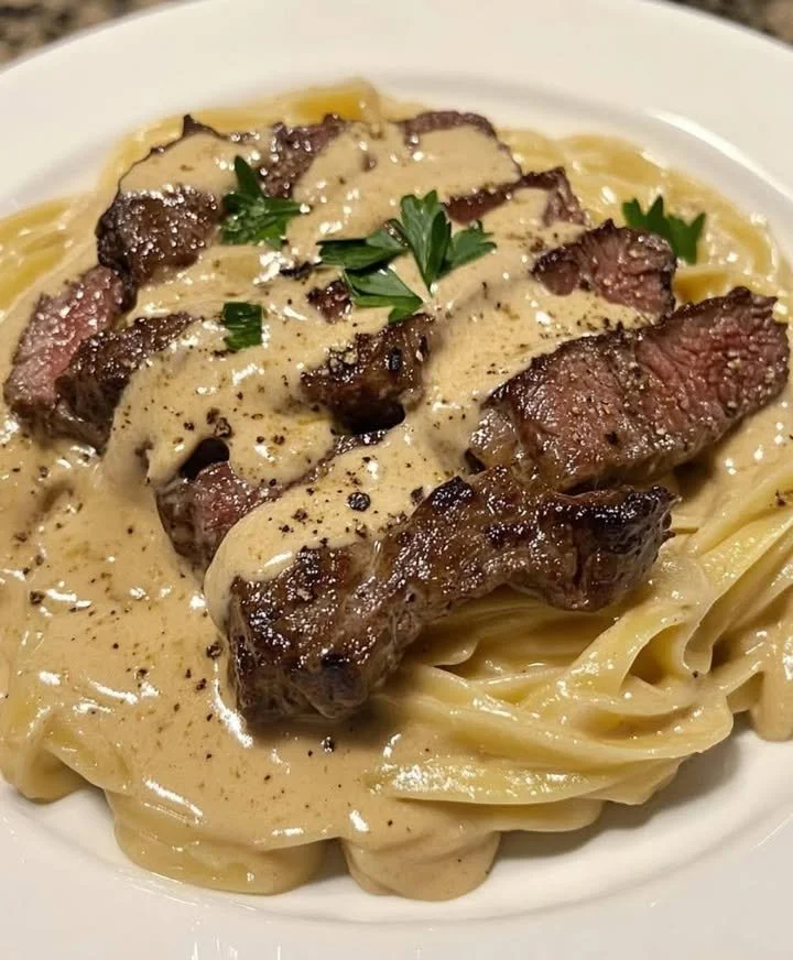 Cajun creamy steak alfredo dish with steak and pasta in a rich sauce.