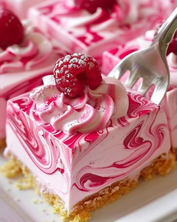 Delicious creamy raspberry cheesecake topped with fresh raspberries