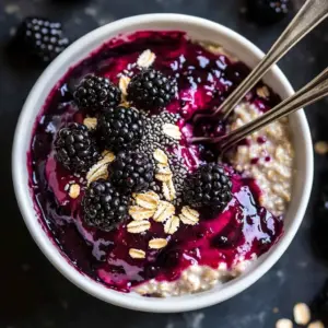 Bowl of easy blackberry chocolate chip overnight oats topped with fresh blackberries and chocolate chips.