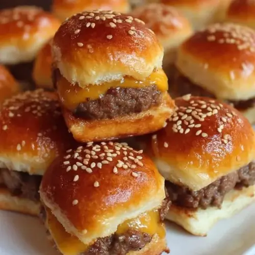 Mini beef cheeseburger sliders stacked on a plate