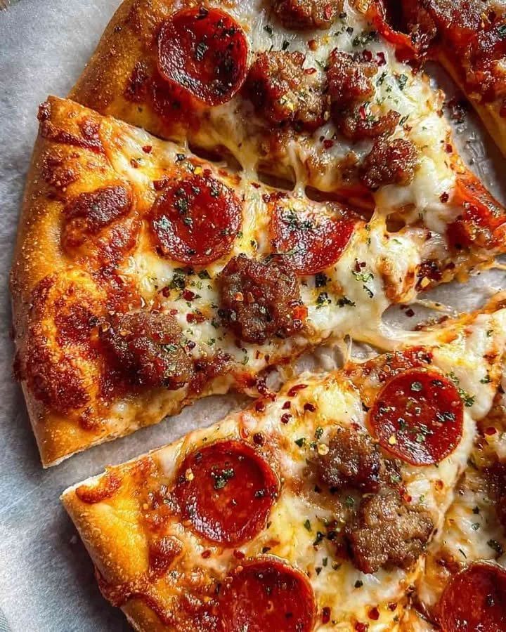 Delicious pepperoni sausage pizza slice topped with chili flakes