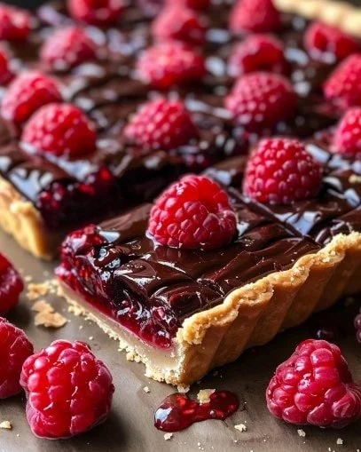 Raspberry Dark Chocolate Pie Bars on a plate garnished with raspberries